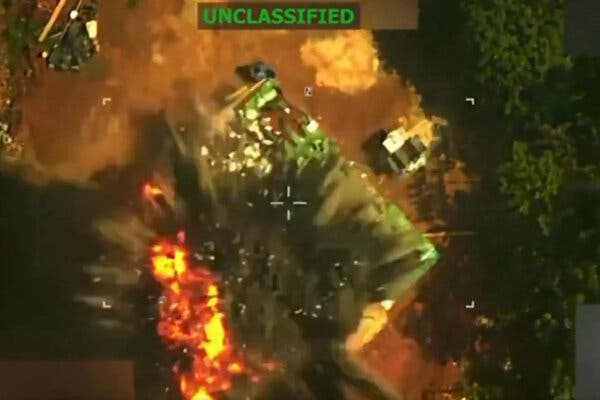 Un vídeo con una retícula muestra una explosión vista desde arriba, en la que se ve cómo salen llamas y humo de un edificio. Está etiquetado como “no clasificado”.